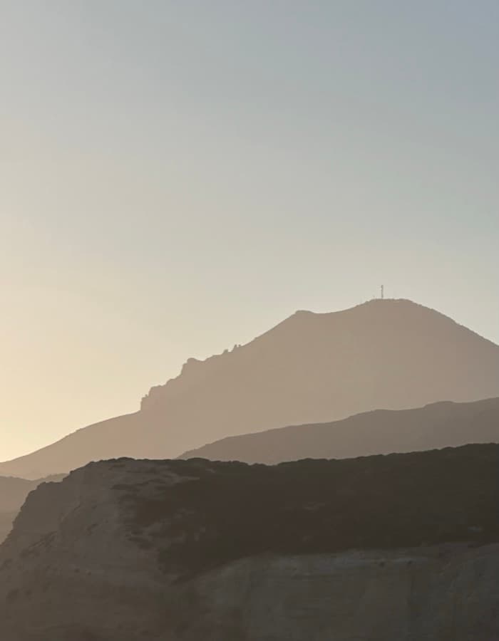 Layered mountain silhouettes in soft dusk light